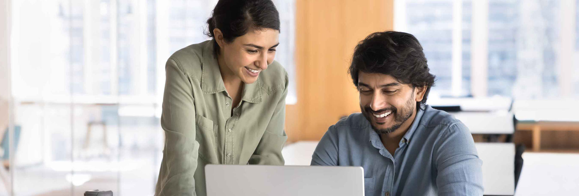 Two people smiling and working together